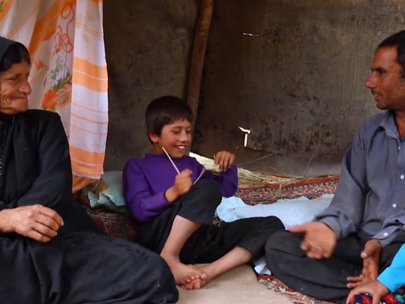Film still from Asho. Family in Iran sit and converse. 